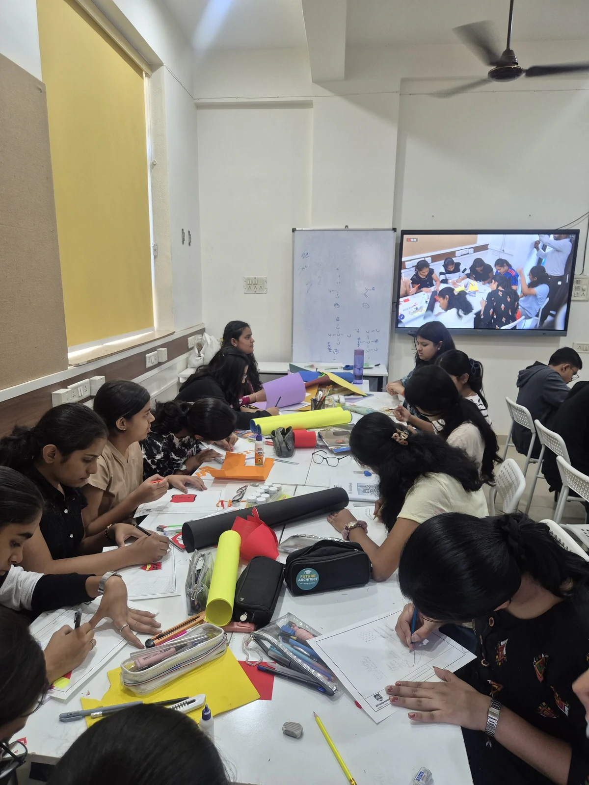 AICT students working with drawings and model-making materials in the classroom