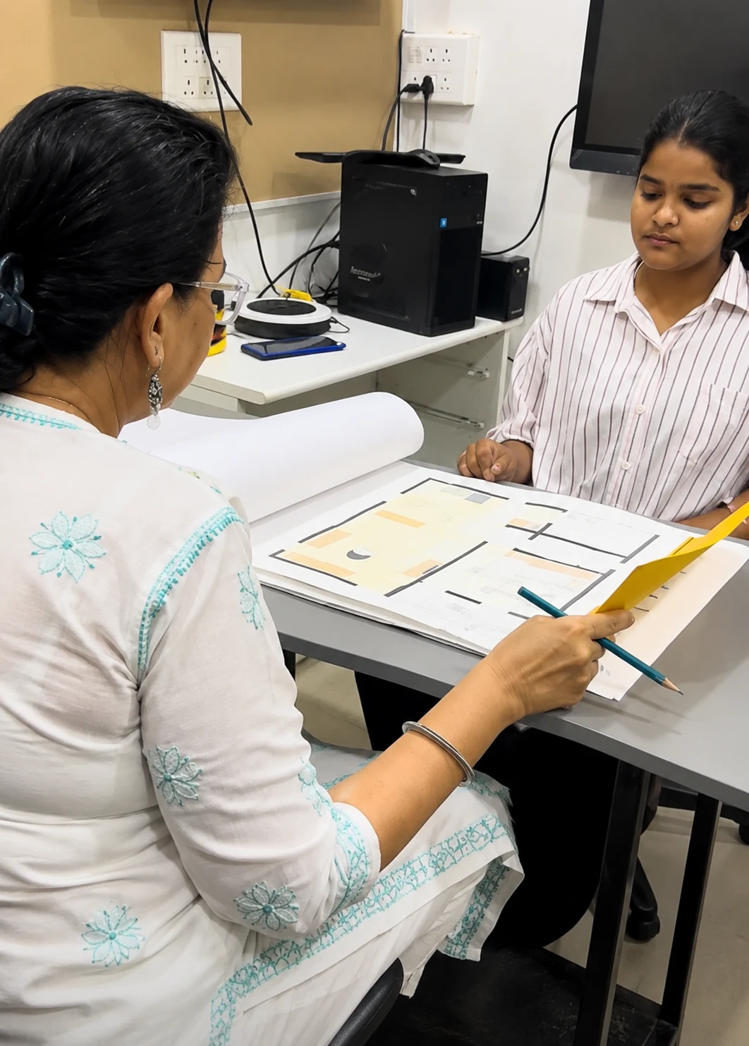 AICT student discussing an interior design project with a faculty member