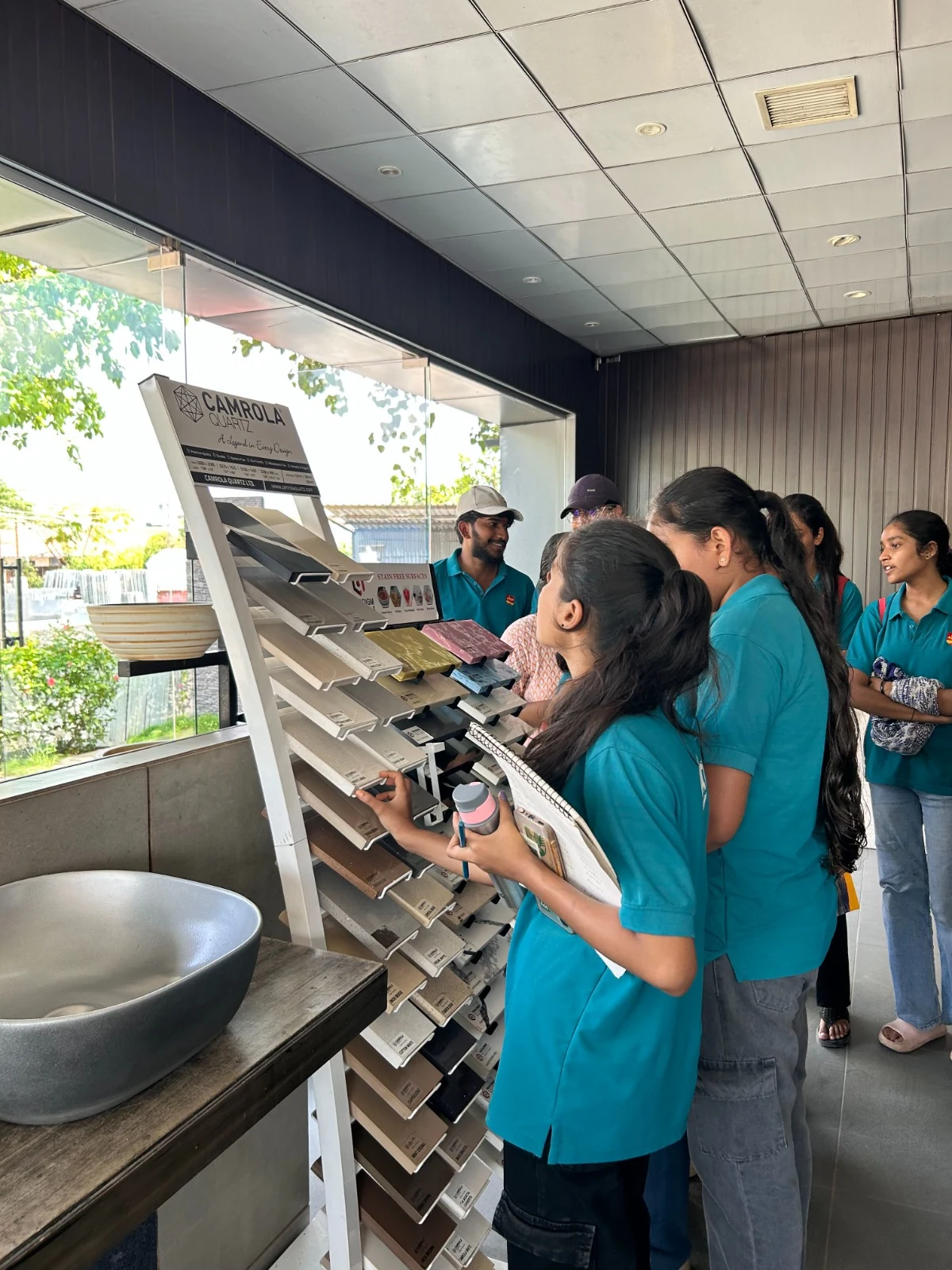 AICT learners examining finish and material samples during a showroom visit