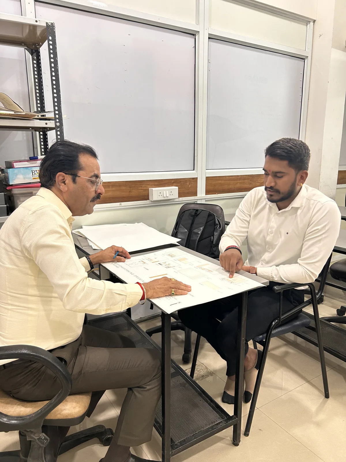 AICT student discussing design drawings with a faculty member